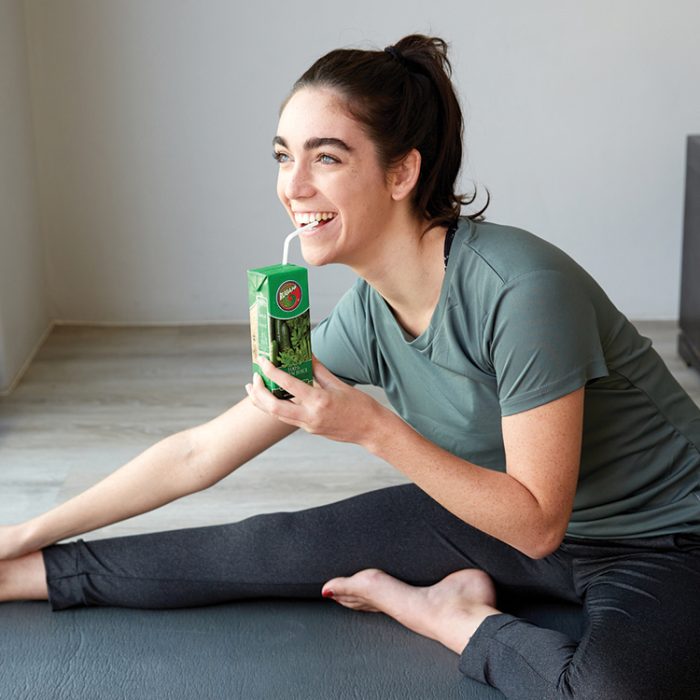 Young Female adult stretching whilst enjoying some Rugani Green Juice